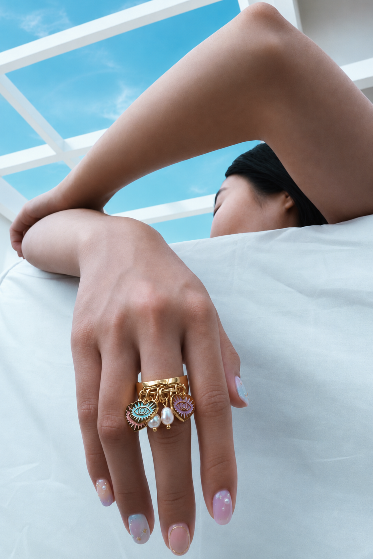 gold ring with dangling evil-eye and pearl charms